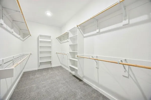 a view of walk in closet with empty racks