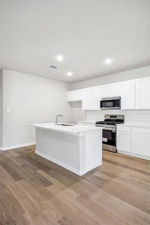 a kitchen with a sink stainless steel appliances and white cabinets