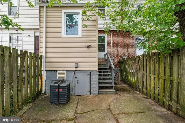a view of a house with a backyard and wooden fence