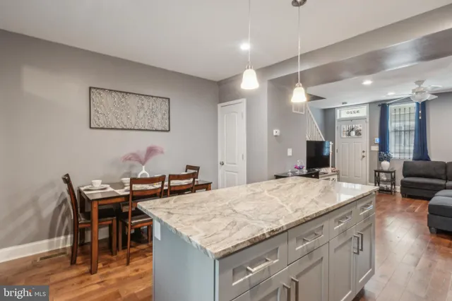 a view of kitchen island with granite countertop dining room and wooden floor