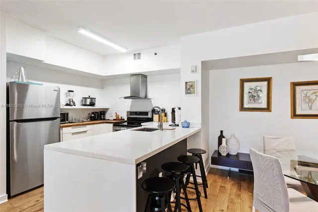 a kitchen with a sink a stove top oven and white stainless steel appliances