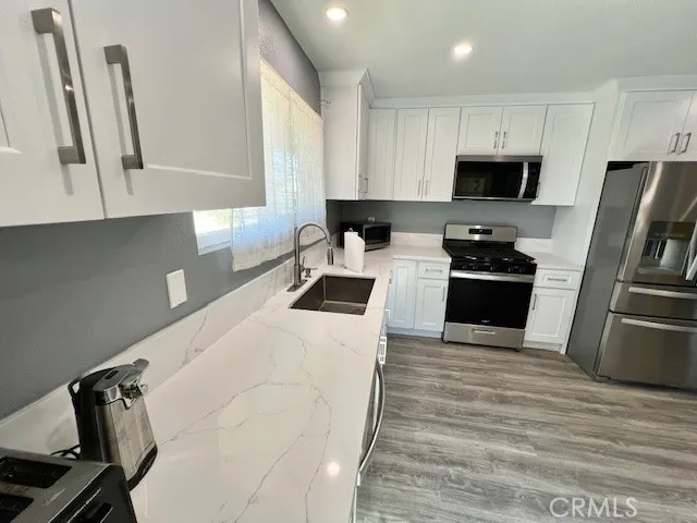 a kitchen with white cabinets and stainless steel appliances
