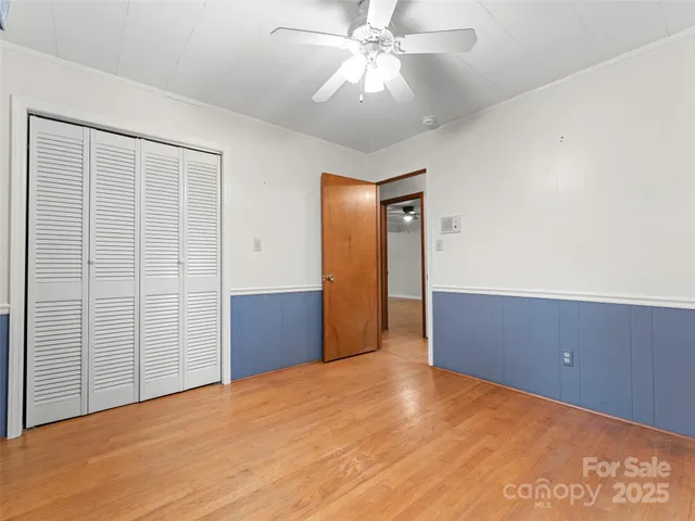 an empty room with a window and a ceiling fan