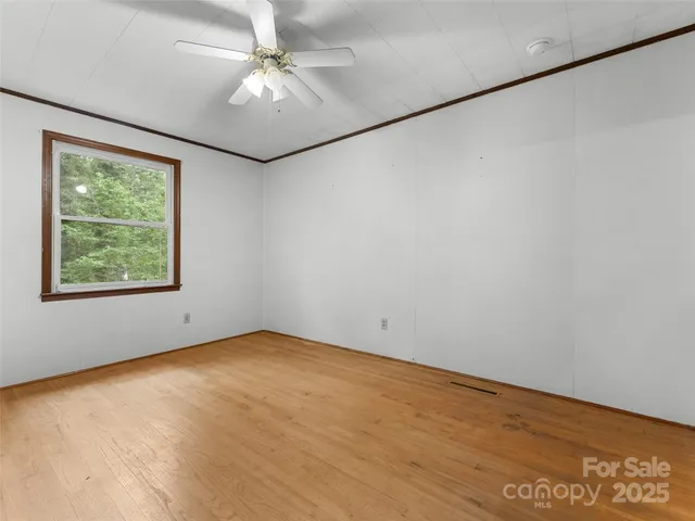 an empty room with chandelier fan