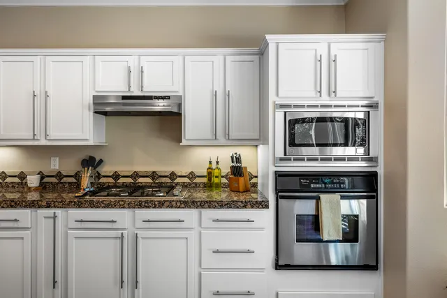 a kitchen with stainless steel appliances granite countertop a sink and cabinets