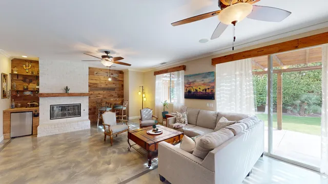 a living room with fireplace furniture and a large window