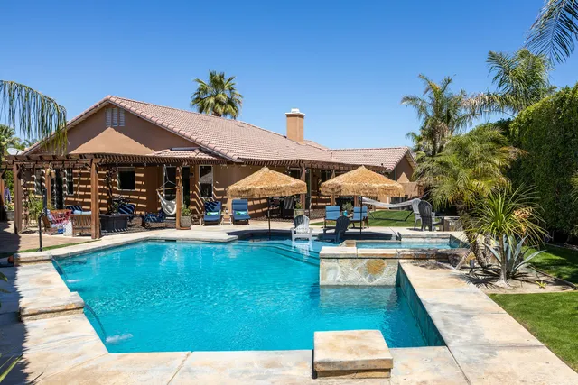 a swimming pool with outdoor seating and yard
