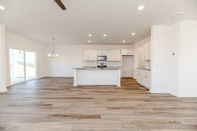 a view of kitchen with granite countertop cabinets and refrigerator