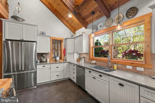 a bedroom with a bed a dresser and a chandelier