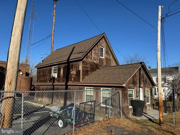 a view of a house with a large window and wooden fence