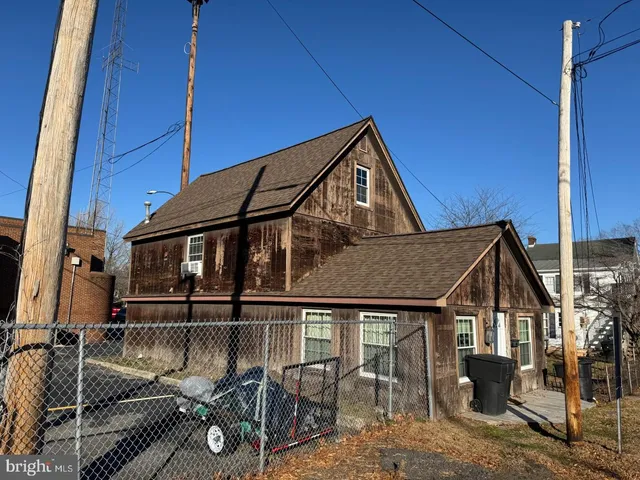 a view of a house with a large window and wooden fence