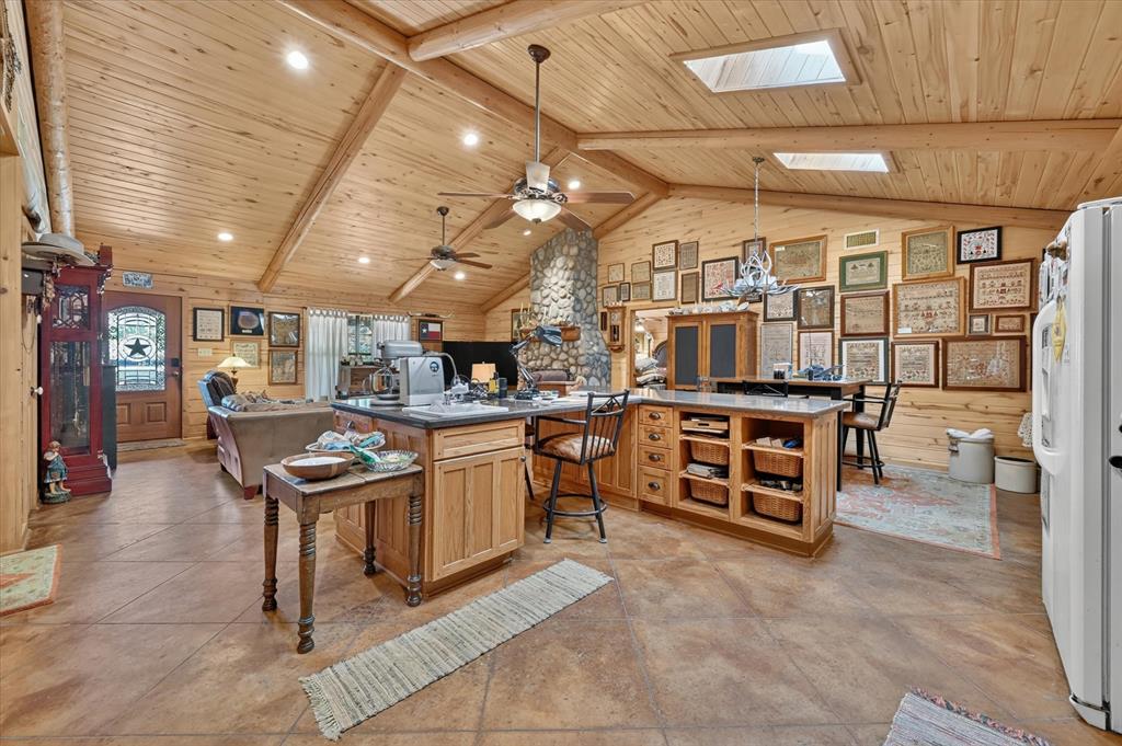 1623 3 Skillet Road Springtown, TX 76082 - Photo 18 of 40 Vaulted wood-paneled ceiling with exposed beams, skylights, recessed lighting, and ceiling fans