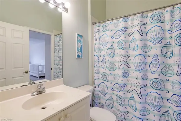 a bathroom with a sink and mirror with shower curtain