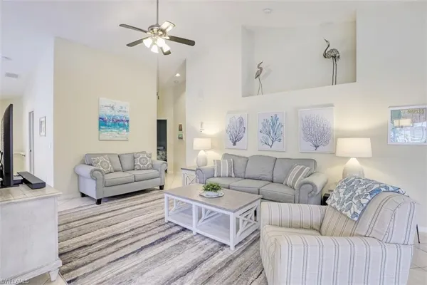 a living room with furniture a flat screen tv and a couch