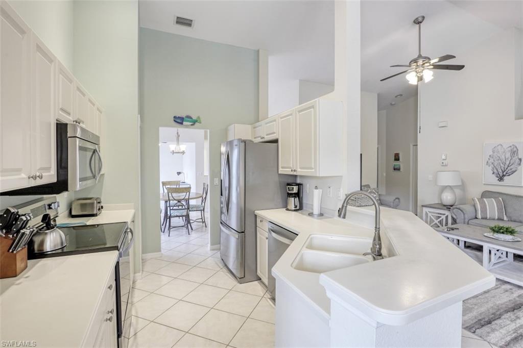 5630 Sherborn Drive, Unit 202 Naples, FL 34110 - Photo 6 of 18 a kitchen with stainless steel appliances kitchen island granite countertop a sink and cabinets