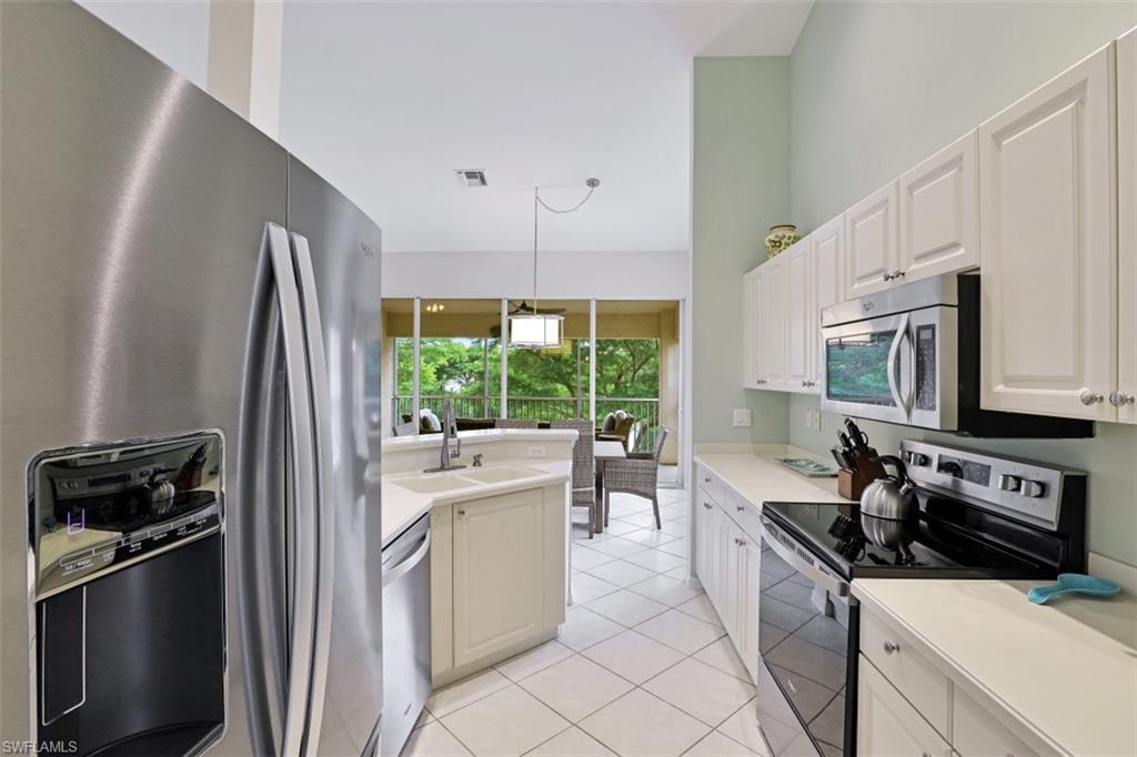 5630 Sherborn Drive, Unit 202 Naples, FL 34110 - Photo 7 of 18 a kitchen with stainless steel appliances a refrigerator sink and stove