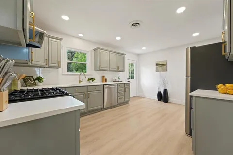 a kitchen with stainless steel appliances a stove a sink a refrigerator and cabinets