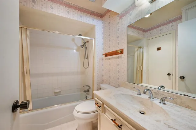 a bathroom with a granite countertop sink toilet and shower