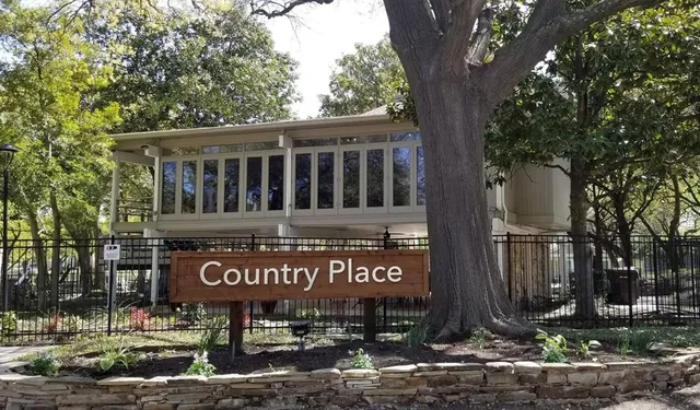 a view of a sign board with large trees