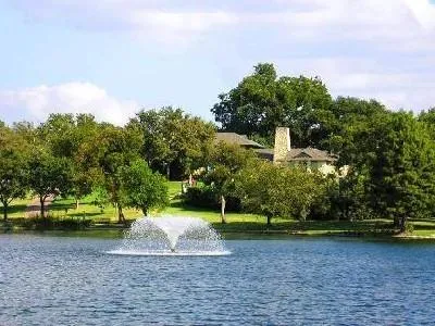 a view of a tennis ground with large trees