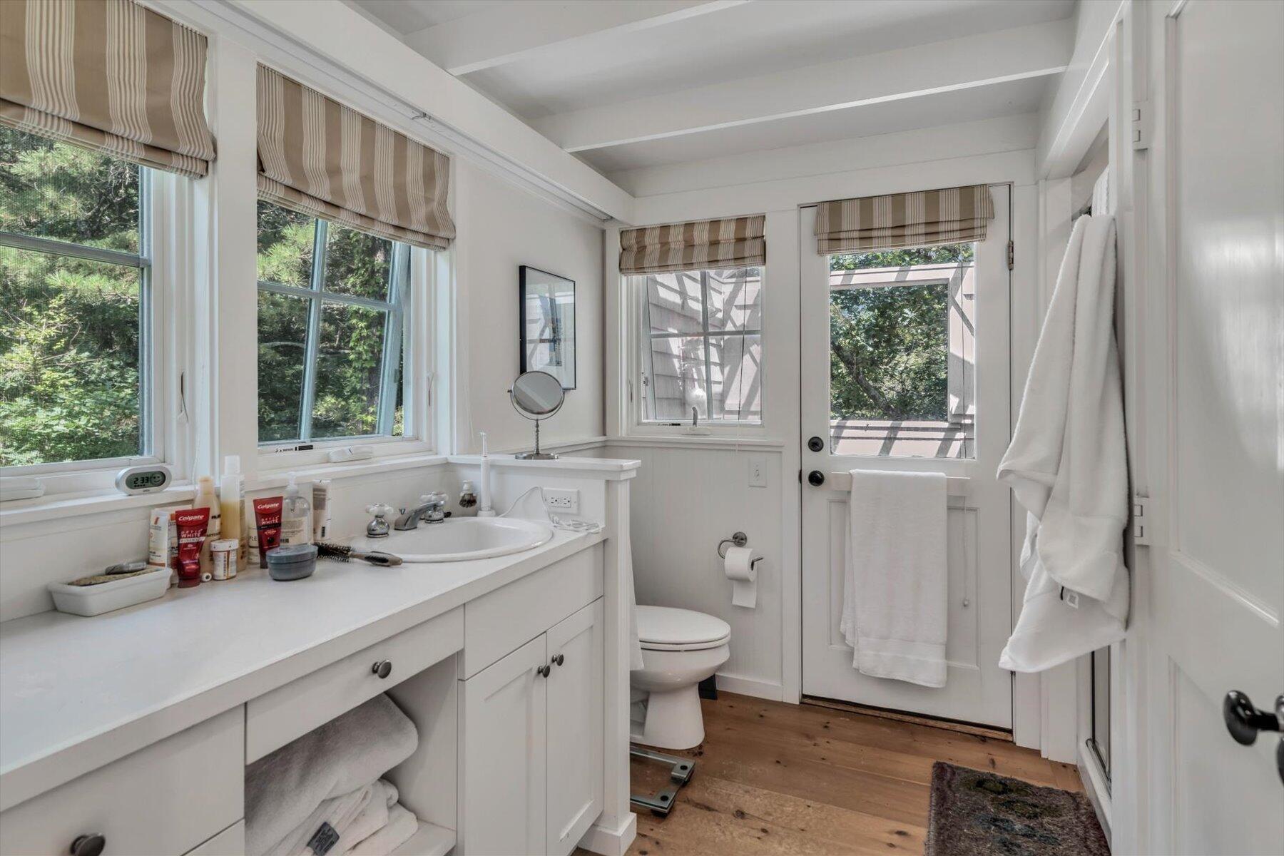 16 Tom's Hill Road Truro, MA 02666 - Photo 14 of 27 a bathroom with a sink a toilet a large mirror and a window