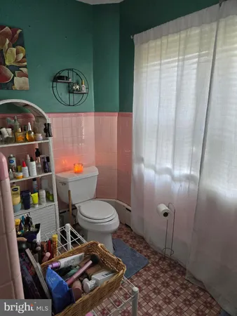 a bathroom with a toilet and a shower curtain