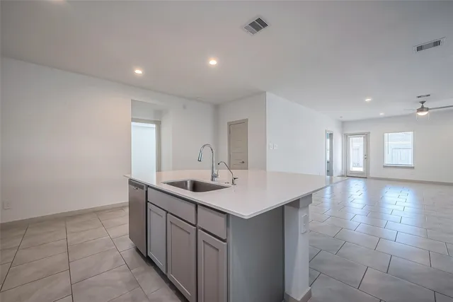 a view of a kitchen island a sink and dishwasher with wooden floor