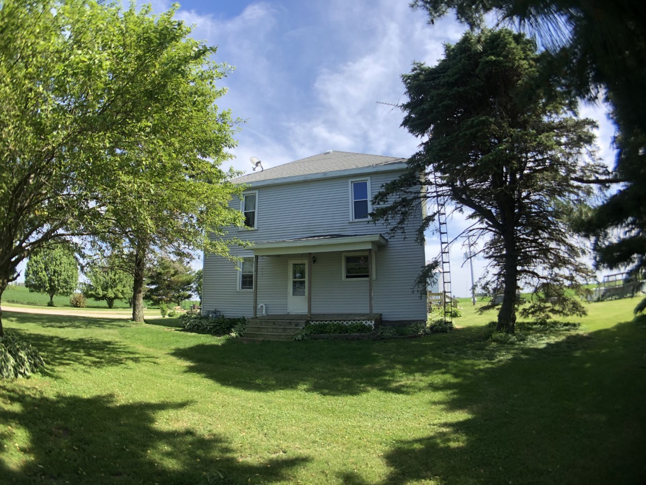 1112 North 33rd Road Ottawa, IL 61350 - Photo 2 of 2 a view of a white house with a big yard and potted plants and large trees