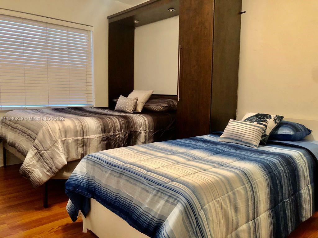 4220 Southwest 13th Street, Unit 4220 Miami, FL 33134 - Photo 14 of 14 a bedroom with two beds and wooden floor