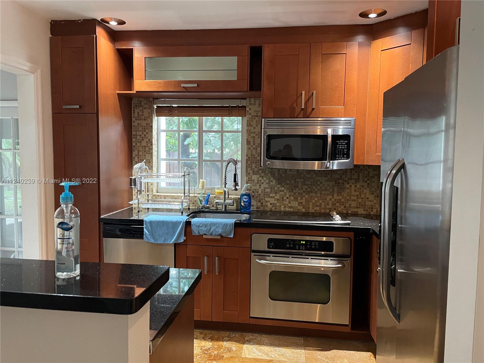 4220 Southwest 13th Street, Unit 4220 Miami, FL 33134 - Photo 5 of 14 a kitchen with a stove and a microwave