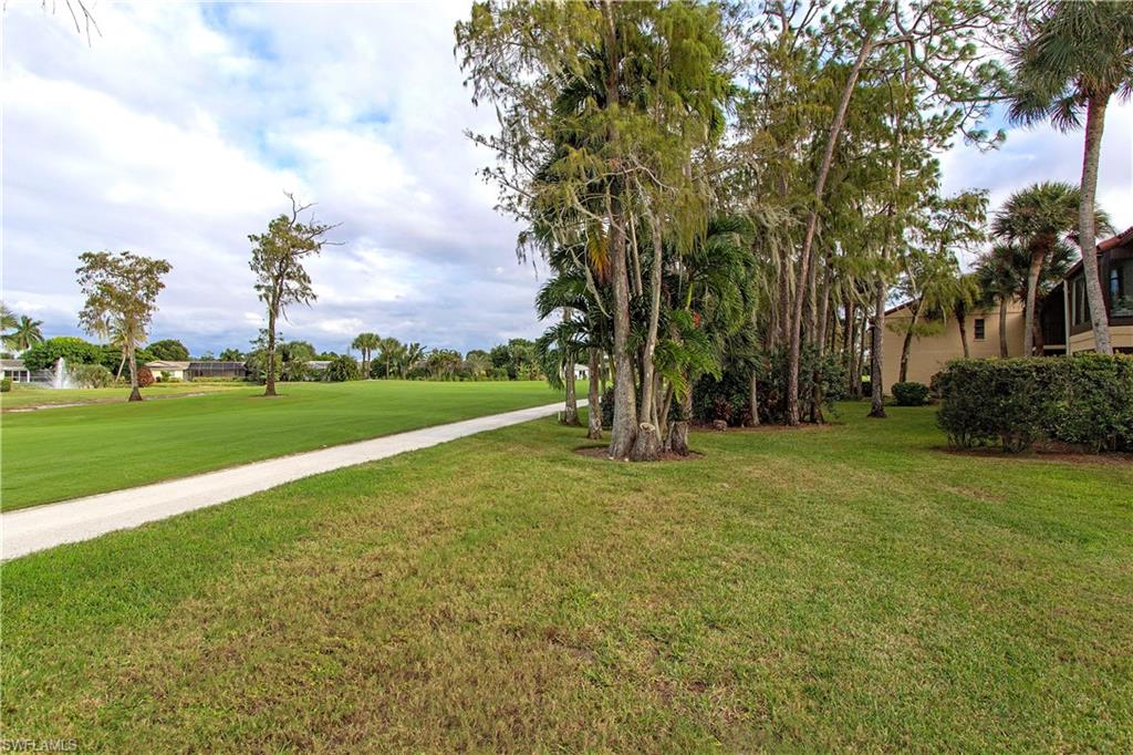 194 Albi Road, Unit 8 Naples, FL 34112 - Photo 11 of 12 a backyard of a house with lots of green space and trampoline