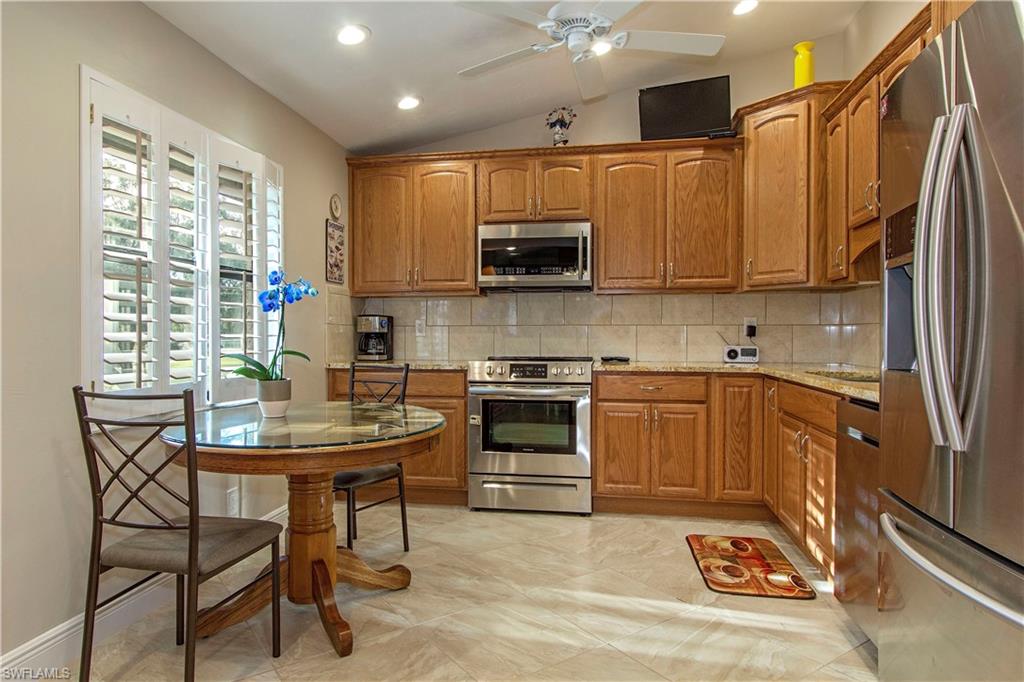 194 Albi Road, Unit 8 Naples, FL 34112 - Photo 5 of 12 a kitchen with stainless steel appliances granite countertop a stove a sink and a microwave
