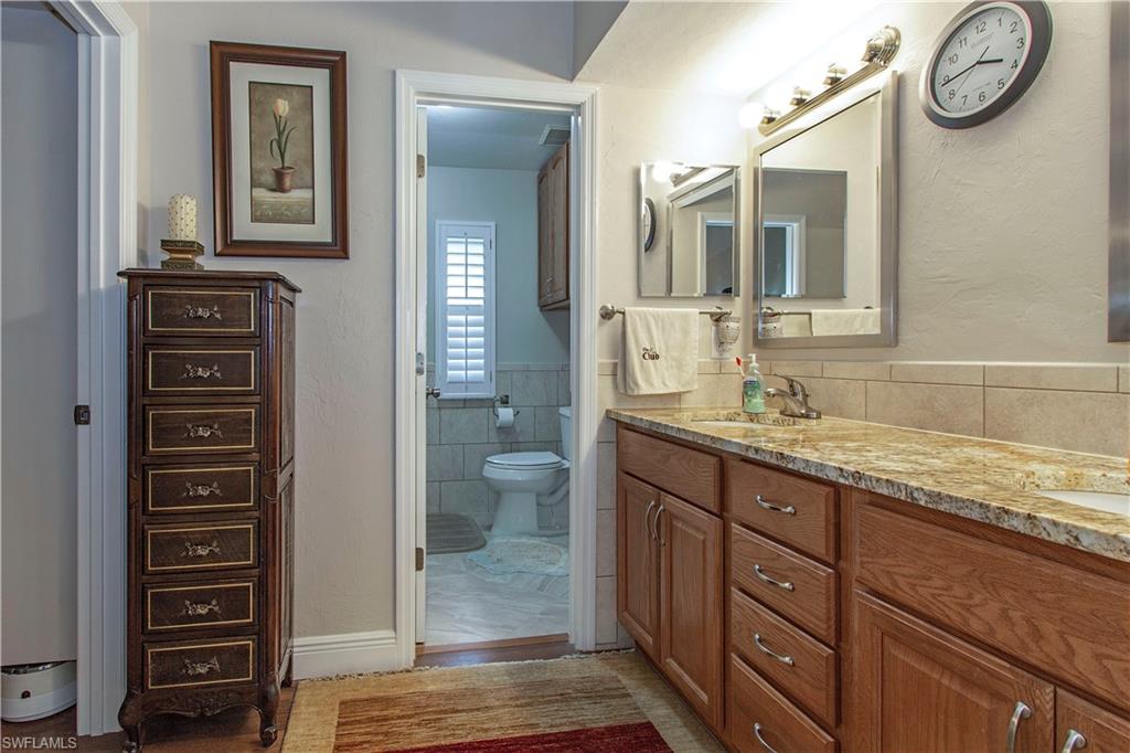 194 Albi Road, Unit 8 Naples, FL 34112 - Photo 8 of 12 a bathroom with a granite countertop sink a mirror and a shower