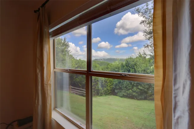a bedroom with a bed and a large window