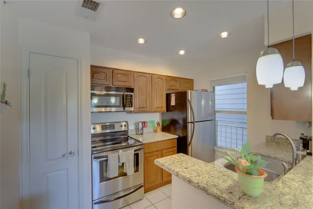 a kitchen with stainless steel appliances granite countertop a sink stove and refrigerator