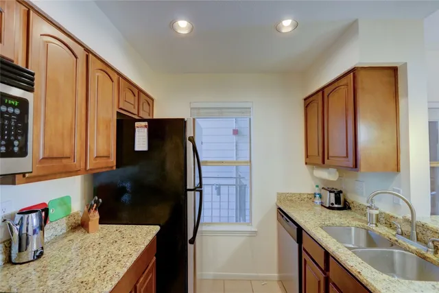 a kitchen with a refrigerator sink and cabinets