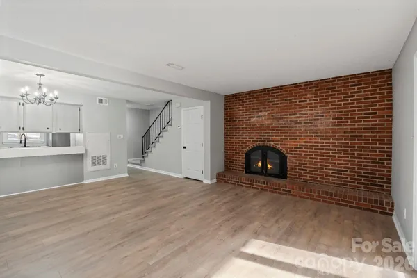 a view of an empty room with a fireplace and a window