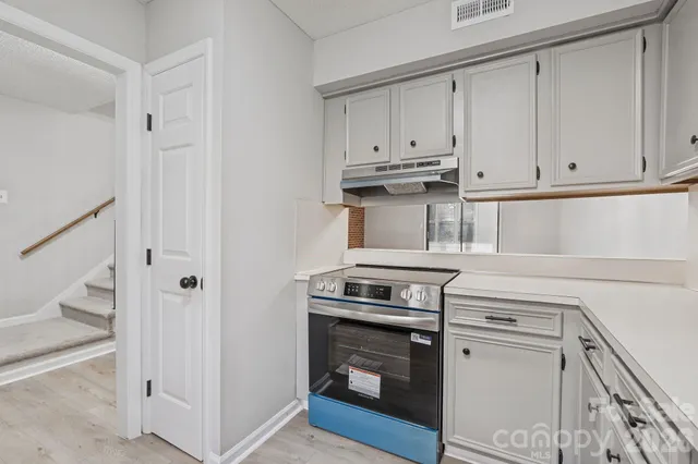 a kitchen with white cabinets and white appliances