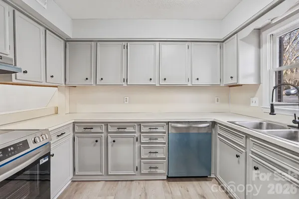 a kitchen with white cabinets appliances and a sink