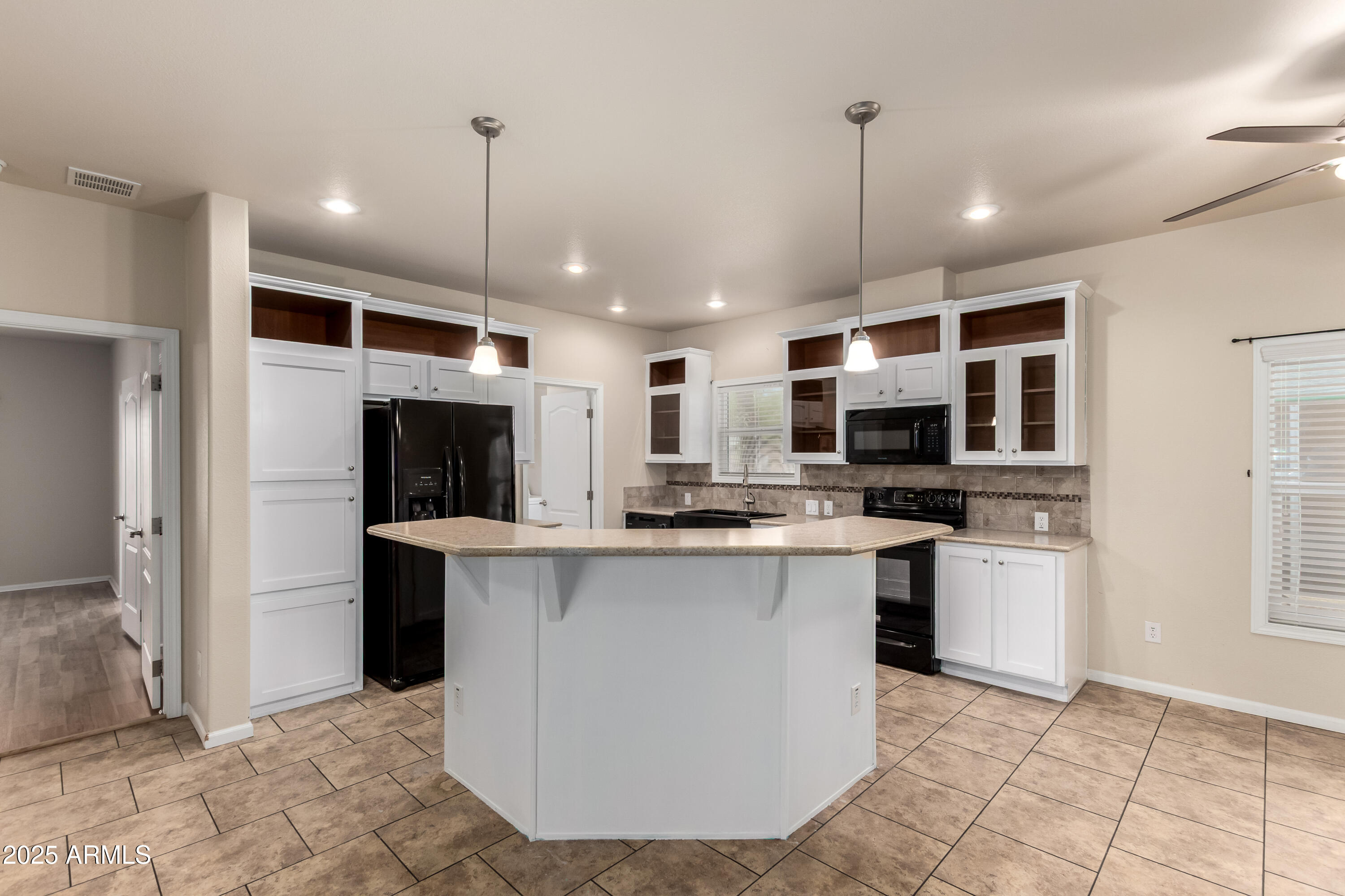 2000 South Apache Road, Unit 78 Buckeye, AZ 85326 - Photo 2 of 8 a kitchen with stainless steel appliances granite countertop a stove top oven a sink dishwasher a refrigerator and a dining table with white cabinets