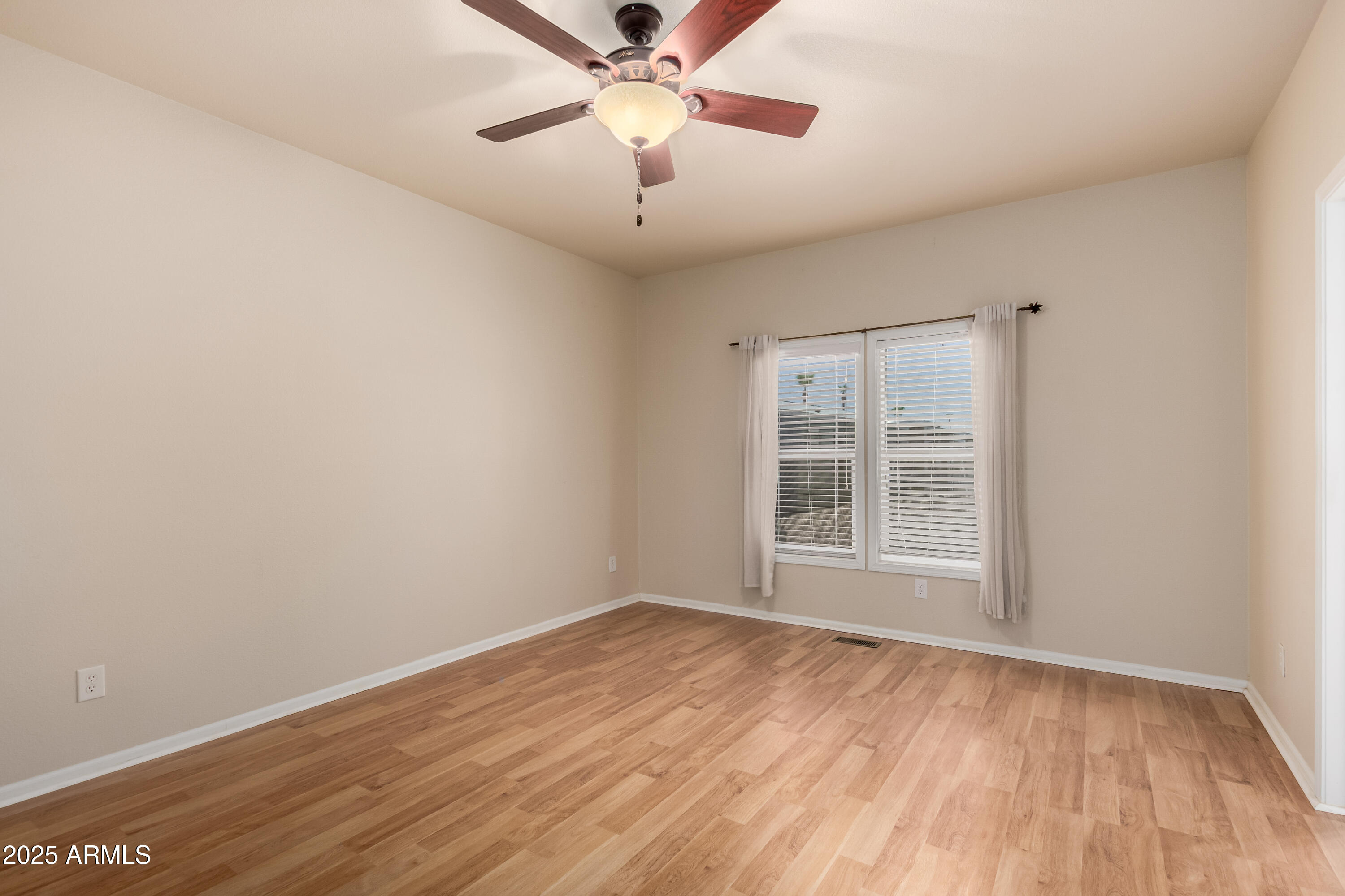 2000 South Apache Road, Unit 78 Buckeye, AZ 85326 - Photo 8 of 8 a view of an empty room with wooden floor and a window