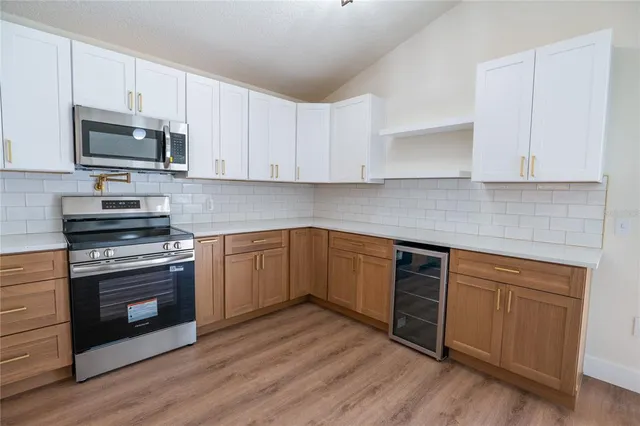 a kitchen with stainless steel appliances white cabinets a sink and a stove
