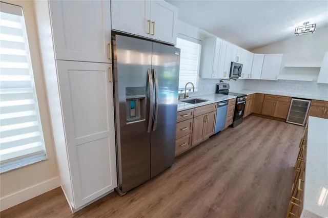 a kitchen with stainless steel appliances granite countertop a refrigerator a sink and a stove