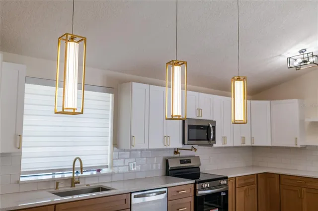 a kitchen with stainless steel appliances granite countertop a sink a stove and a microwave