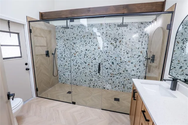 a bathroom with a sink a mirror a vanity and a shower