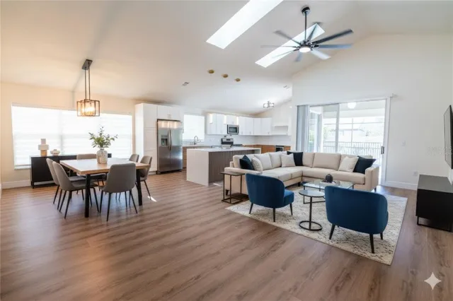 a living room with furniture dining table a window and appliances