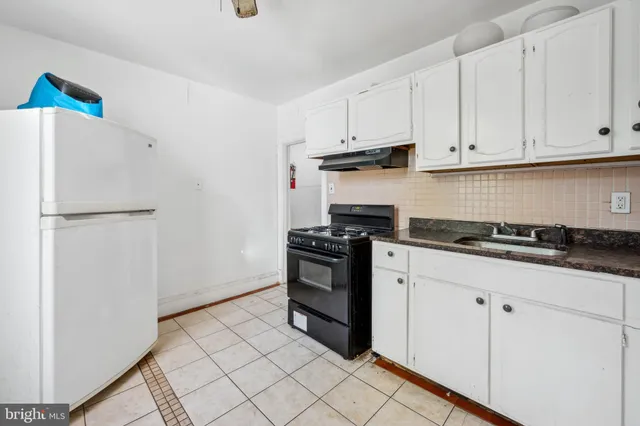 a kitchen with granite countertop a sink stove and refrigerator