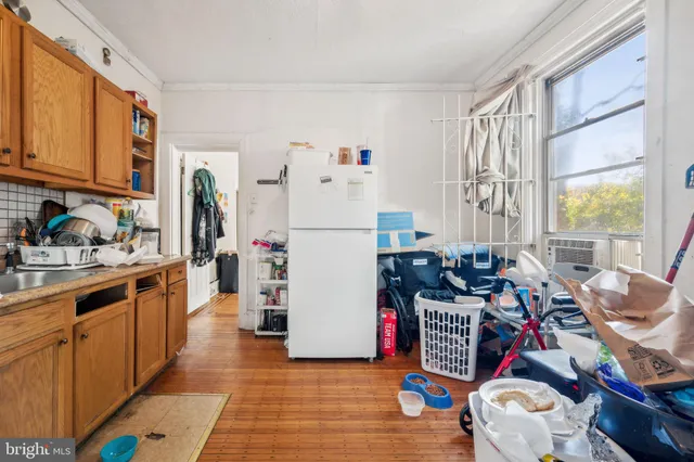 a kitchen with stainless steel appliances a refrigerator and wooden floor