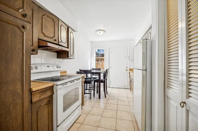 a kitchen with stainless steel appliances granite countertop a table chairs sink and cabinets