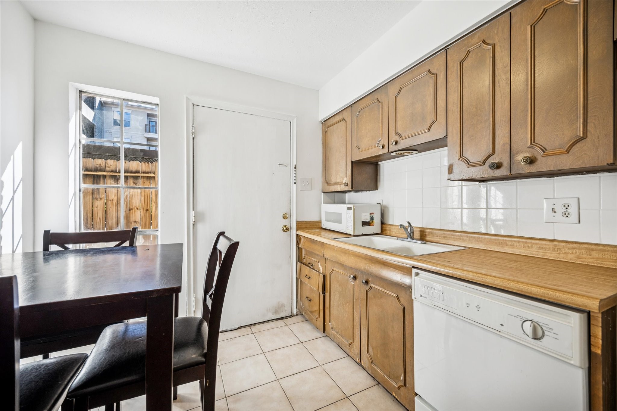 7600 Burgoyne Road, Unit 143 Houston, TX 77063 - Photo 6 of 17 a kitchen with stainless steel appliances granite countertop a table chairs sink and cabinets